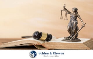 A statue of Lady Justice and hammer emerging from a book on a table