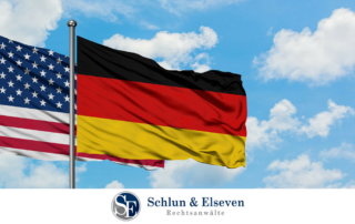 German and US flags with a blue sky background